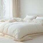 Μια ζεστή και άνετη κρεβατοκάμαρα με ένα φουντωτό πάπλωμα που αναδεικνύει τη σημασία του καθαρισμού του για υγιή ύπνο.