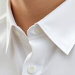 Λευκό πουκάμισο με κιτρινισμένο γιακά και προϊόντα πλυσίματος στο φόντο.