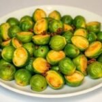 Πιάτο με ψημένα λαχανάκια Βρυξελλών διακοσμημένα με βότανα.