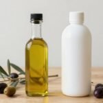 Γυάλινο και πλαστικό μπουκάλι ελαιόλαδου σε ξύλινο τραπέζι με ελιές