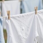 Φρέσκα ρούχα που στεγνώνουν στον ήλιο με κοντινή λήψη της μαγειρικής σόδας δίπλα τους.