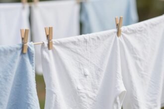 Φρέσκα ρούχα που στεγνώνουν στον ήλιο με κοντινή λήψη της μαγειρικής σόδας δίπλα τους.