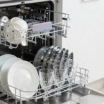 Σύγχρονο πλυντήριο πιάτων γεμάτο καθαρά πιάτα και ποτήρια σε κουζίνα