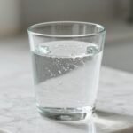 Ανθρακούχο νερό σε γυάλινο ποτήρι, εστίαση στις φυσαλίδες.