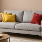 Γκρι καναπές με έντονα χρώματα και ζεστές υφές σε κομψό καθιστικό.