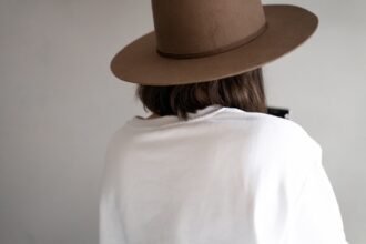woman in white shirt wearing brown fedora hat