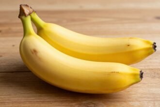 Μπανάνα τοποθετημένη σε ξύλινο τραπέζι φωτισμένη από φυσικό φως.