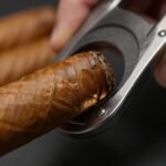 Κοντινό πλάνο από πούρο με γκιλοτίνα κοπής στο φόντο.