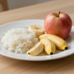 Πιάτο με ελαφριά και εύπεπτα φαγητά για στομαχόπονο, όπως λευκό ρύζι, μπανάνες και μήλα.