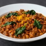 Ένα πιάτο κάρυ με φακές, σπανάκι και κουρκουμά, στημένο όμορφα.