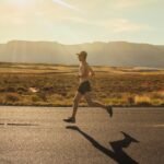 man in black shorts running on gray asphalt road during daytime