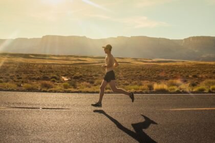 man in black shorts running on gray asphalt road during daytime
