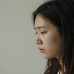 Ένας άνθρωπος κοιτάζει έξω από το παράθυρο, περνώντας από συναισθηματική αβεβαιότητα.