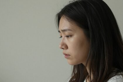 Ένας άνθρωπος κοιτάζει έξω από το παράθυρο, περνώντας από συναισθηματική αβεβαιότητα.