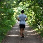 Αθλητής που τρέχει σε μονοπάτι στη φύση.