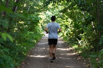 Αθλητής που τρέχει σε μονοπάτι στη φύση.