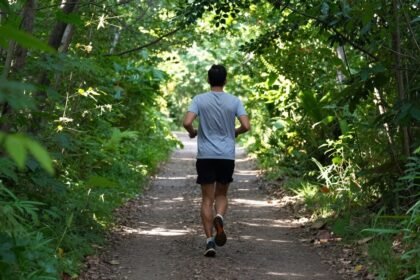 Αθλητής που τρέχει σε μονοπάτι στη φύση.