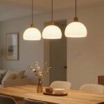 Ένα ζεστό εσωτερικό με κρεμαστά φωτιστικά πάνω από μια τραπεζαρία.