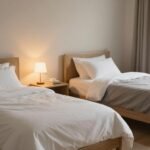 Δύο χωριστά κρεβάτια σε ήρεμο υπνοδωμάτιο, που αντικατοπτρίζει την τάση του χωριστού ύπνου για ζευγάρια.