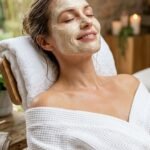 Woman with face mask smiling closed eyes spa setting