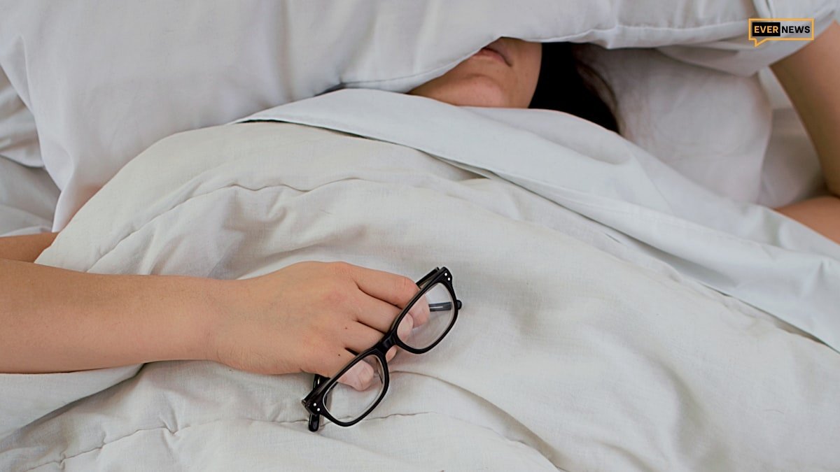 Tired exhausted woman sitting on bed morning light
