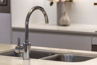 Clean sparkling stainless steel kitchen sink with modern faucet