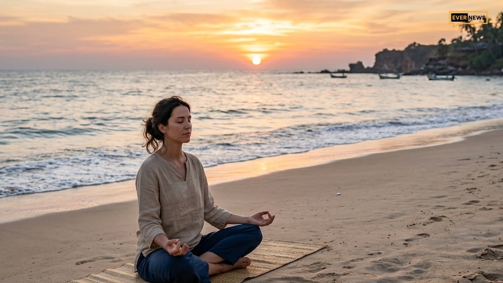 Person meditating on a beach at sunset