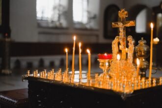 Πιστοί παρακολουθούν λειτουργία σε Ορθόδοξο ναό, βλέποντας το ιερό από πίσω