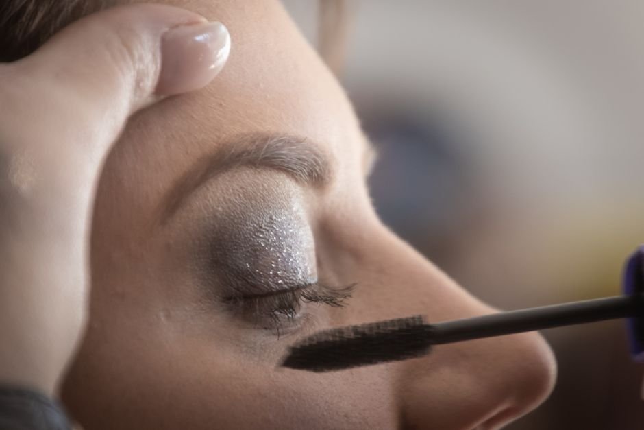 Μακιγιάζ για μεγαλύτερα μάτια 2 A woman\'s eyelid is delicately painted with glamorous shimmery eyeshadow and mascara.
